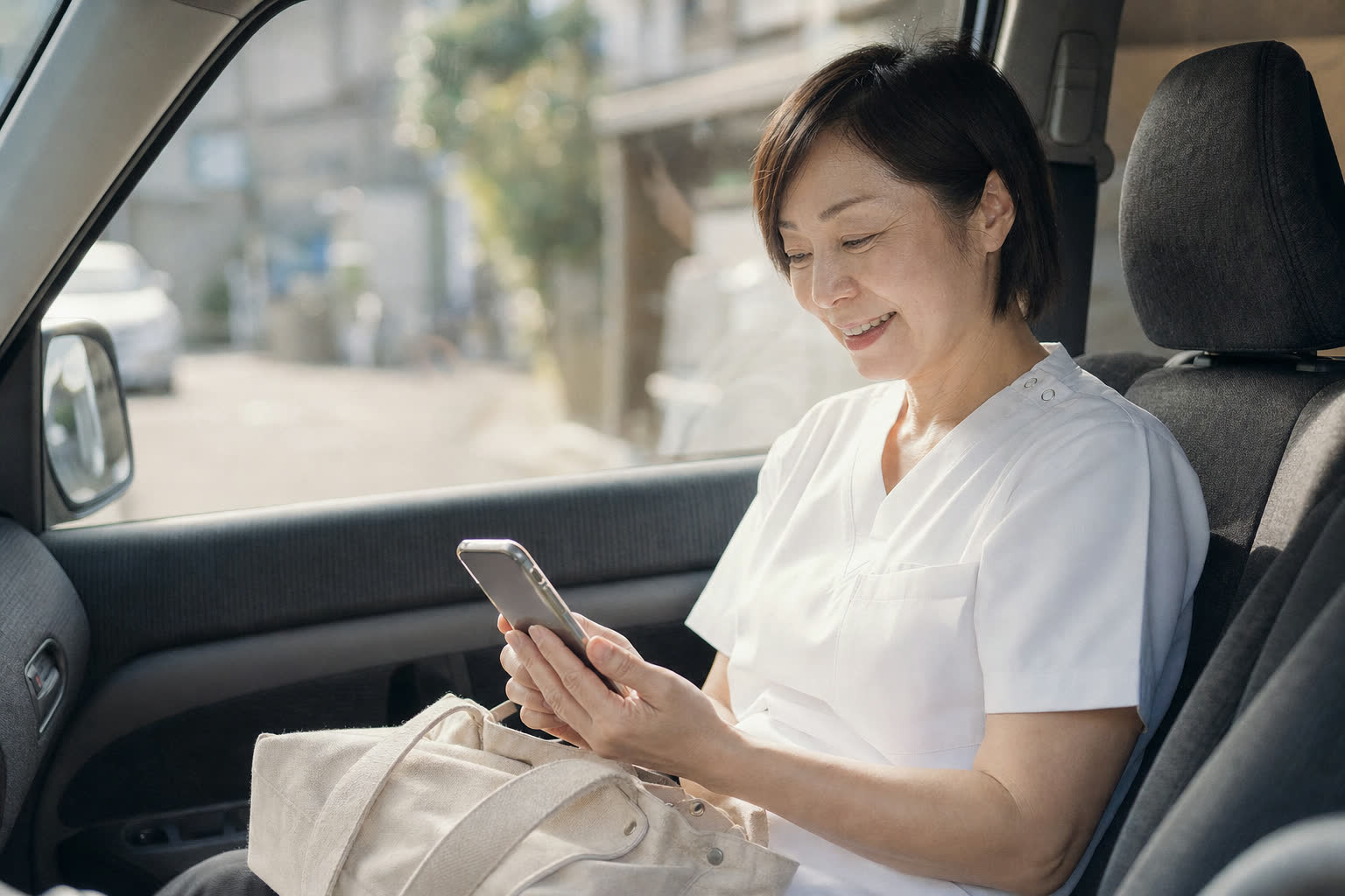 訪問の合間に車内でスマートフォンを見て笑顔になる訪問看護師（AIで生成したイメージ）